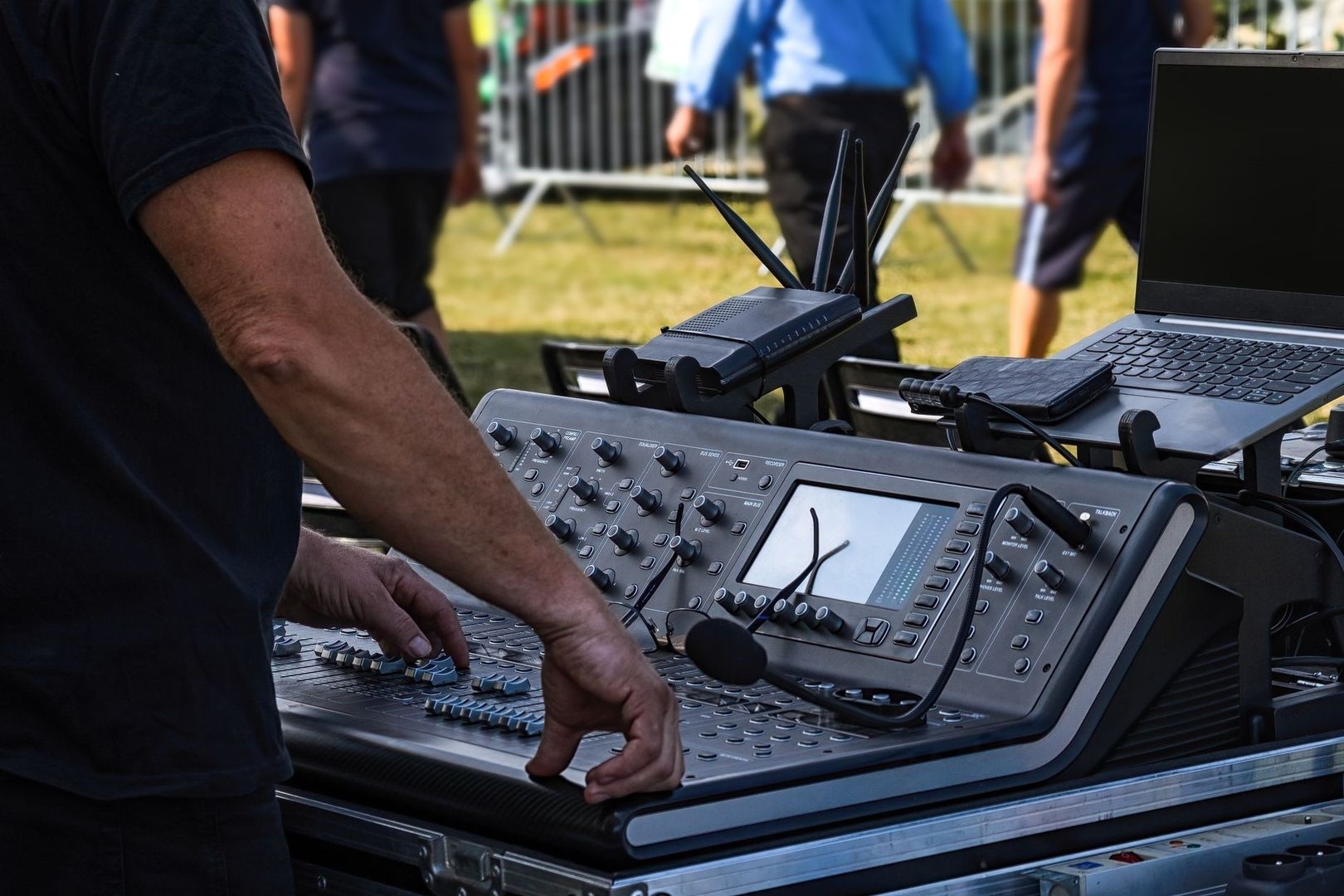Ljudtekniker justerar mixerbord och utrustning inför ett utomhusevenemang