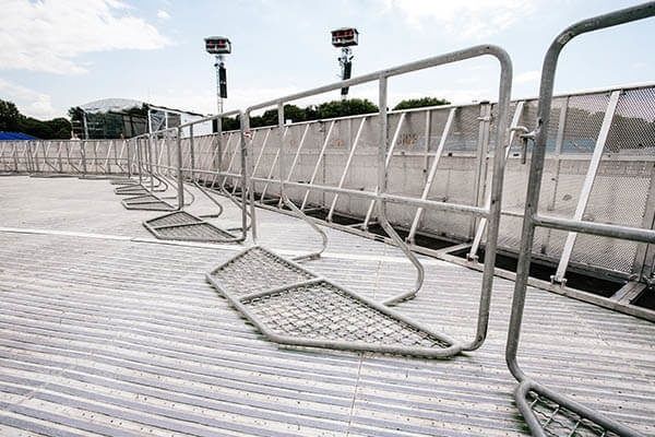 Metallstängsel och säkerhetsbarriärer på en utomhusarena